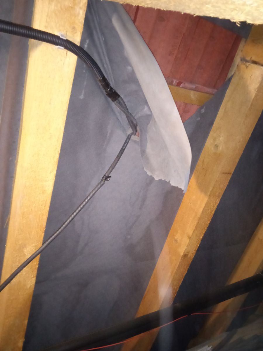 DC kabel z fotovoltaiky protažený přes protrženou podstřešní fólii